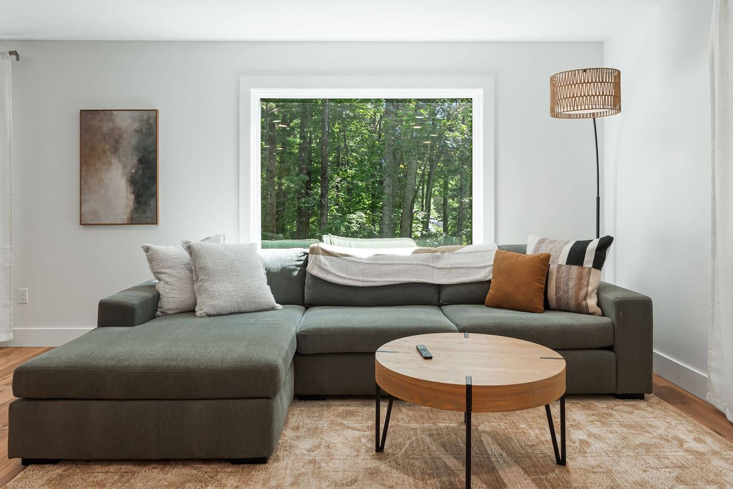 A modern living room with a sectional sofa, a round coffee table, and a floor lamp.