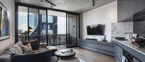 A modern living space with a sofa, coffee table, and a TV mounted on the wall.