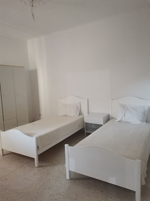 A room with two single beds, a wardrobe, and a bedside table. - Charmante maison confortable, idéale pour un agréable séjour d’hiver à Bizerte (Bizerte)
