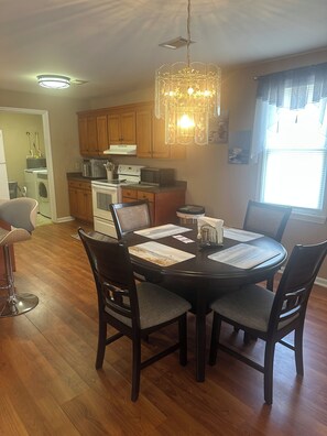 A dining area with a round table, chairs, and a chandelier. - Tranquil 3-bedroom house w/ AC gated parking in charming Historic Selma, Alabama (Selma)