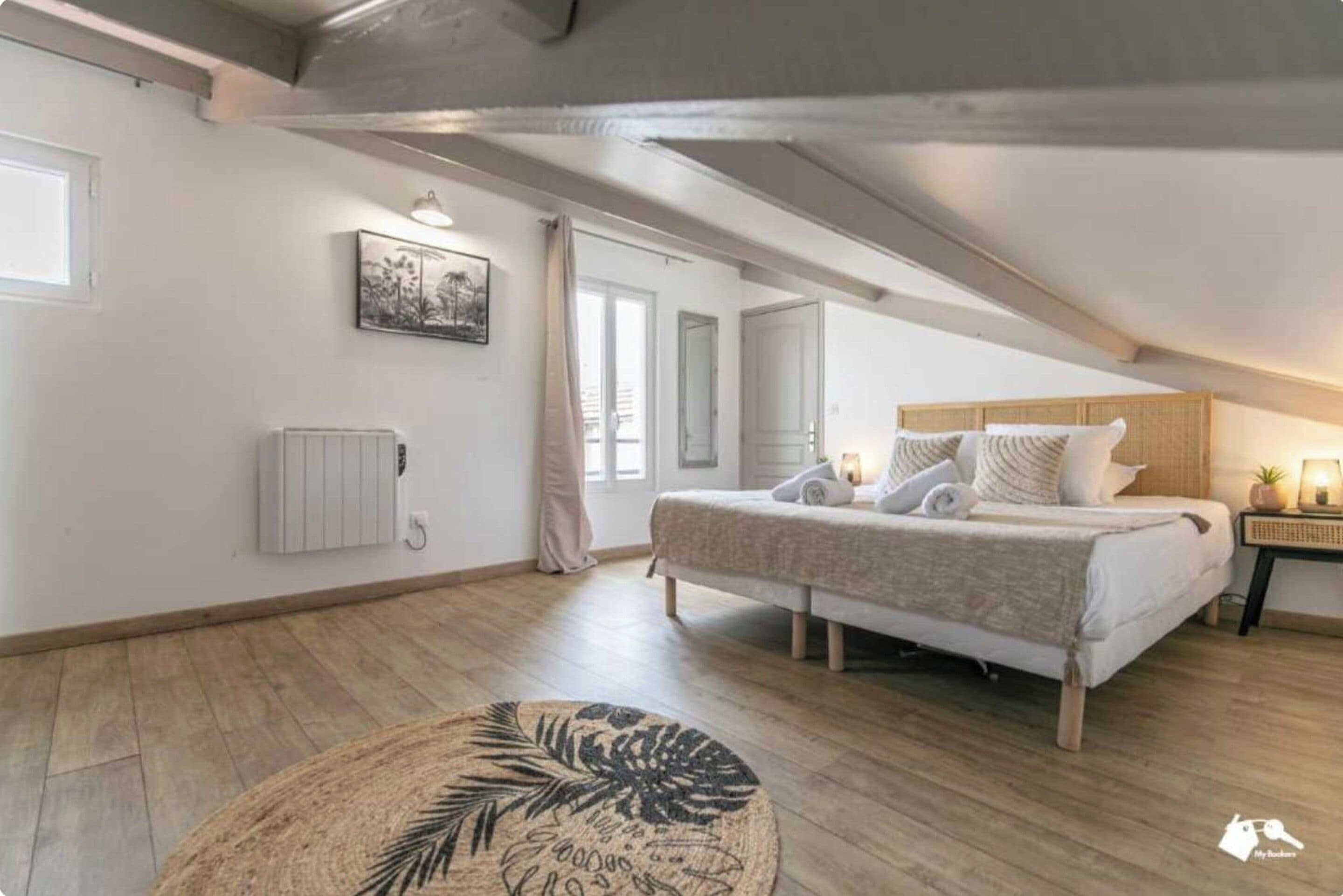 Ein Schlafzimmer mit einem Bett, einem runden Teppich, einem Heizkörper und einem Fenster.