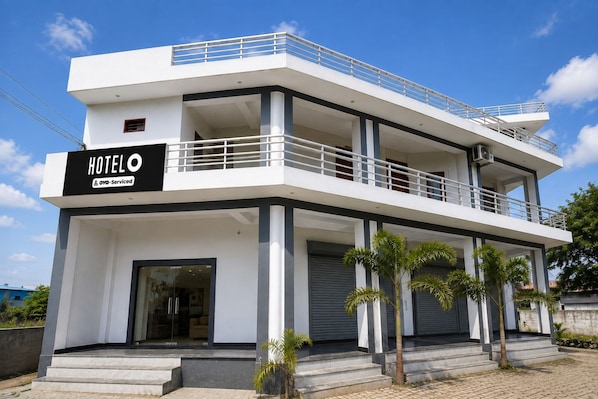 A modern hotel with a two-story structure, a balcony on the upper floor, and a sign indicating it is serviced by Agoda.