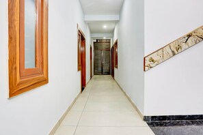 A hallway with wooden doors and a marble wall piece.