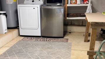 A laundry area with a washing machine, dryer, and a metal water heater.