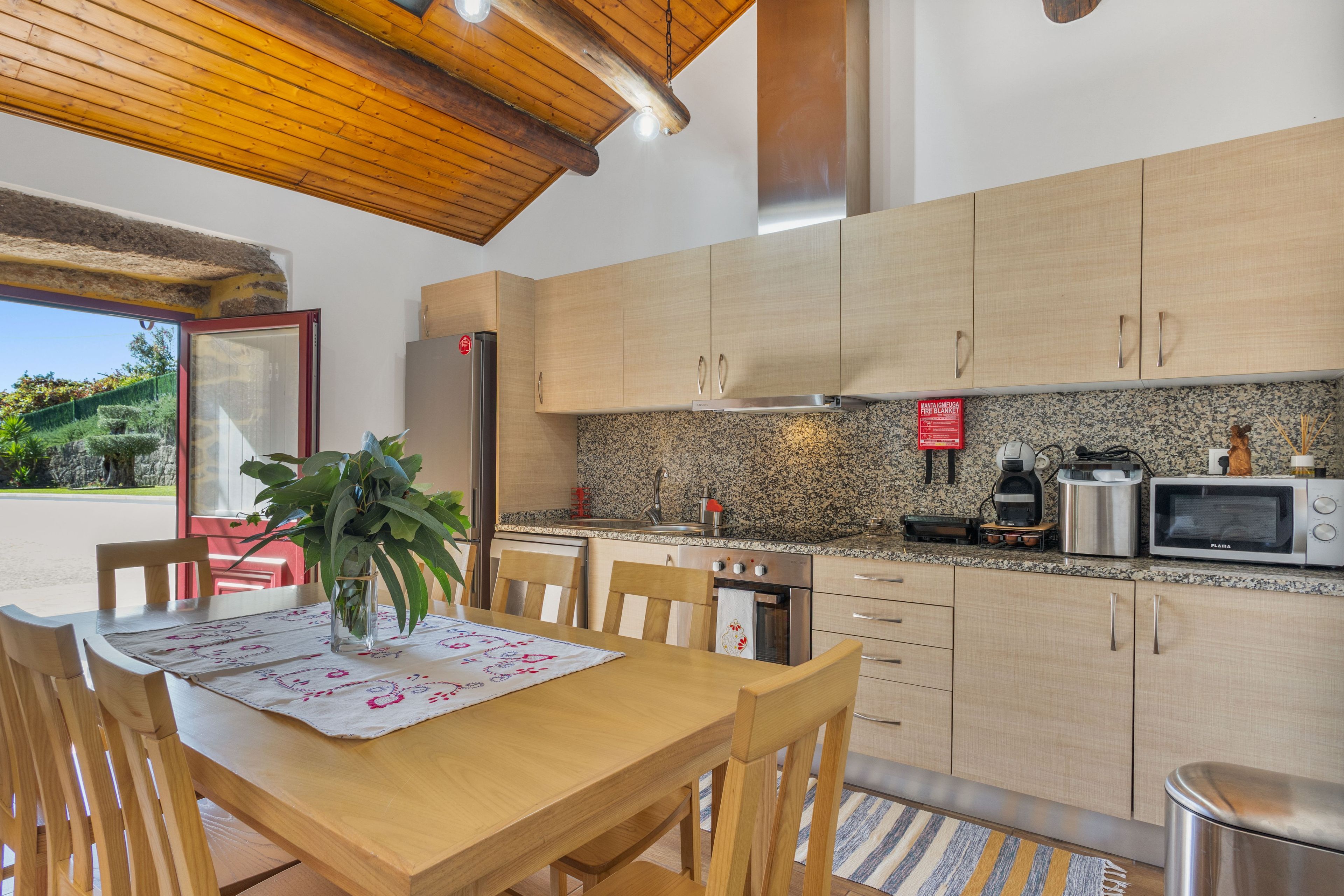 A modern kitchen with wooden cabinets, a granite countertop, and stainless steel appliances.