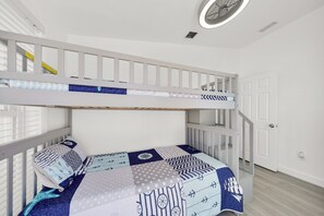 A bunk bed with a blue and white nautical-themed bedding, a white door, and a ceiling fan. - Oceanfront Marathon FL Home w/ Private Dock, Pool & Direct Ocean Access (Marathon)