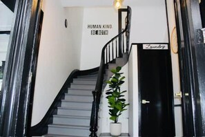 Eine Treppe mit schwarzer Geländer und einem Blumentopf auf der Zwischenebene.