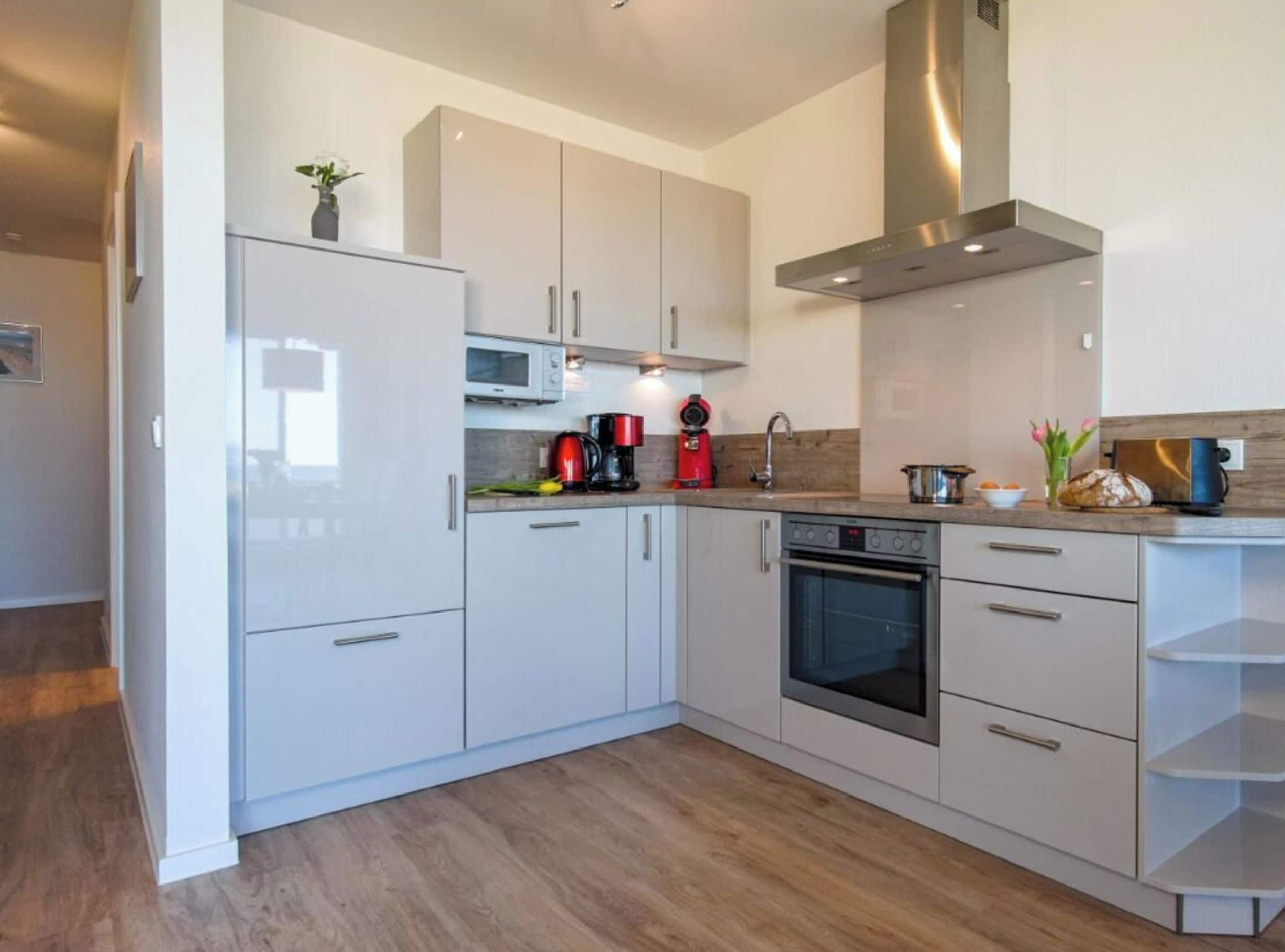 A modern kitchen with white cabinets, a microwave, a coffee maker, and a toaster.