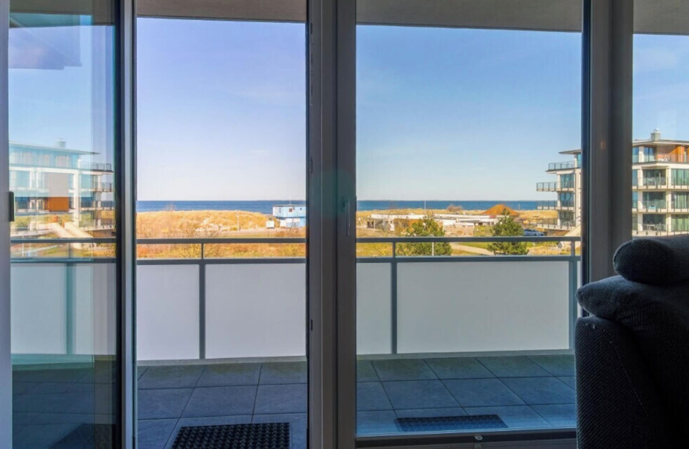 Un balcon avec vue sur la mer et les bâtiments.