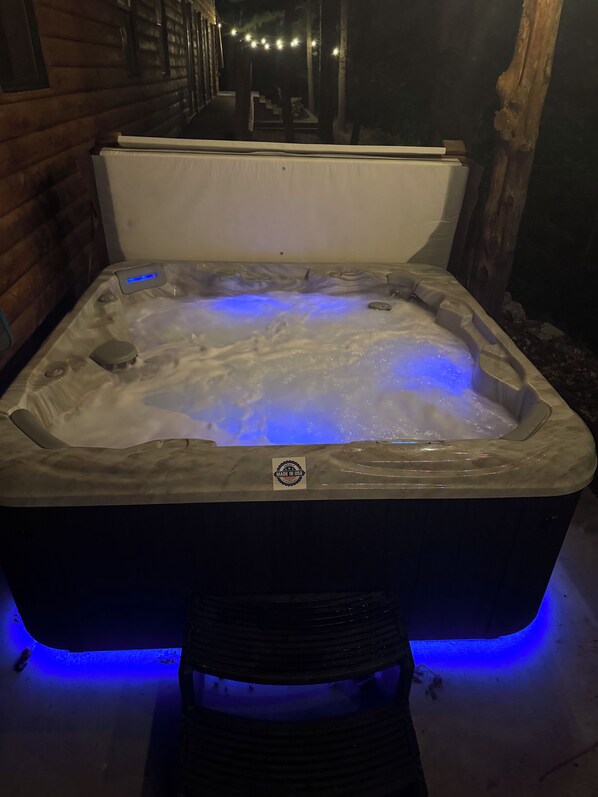 A hot tub with a 'Made in USA' label, surrounded by wooden walls and a stone floor.