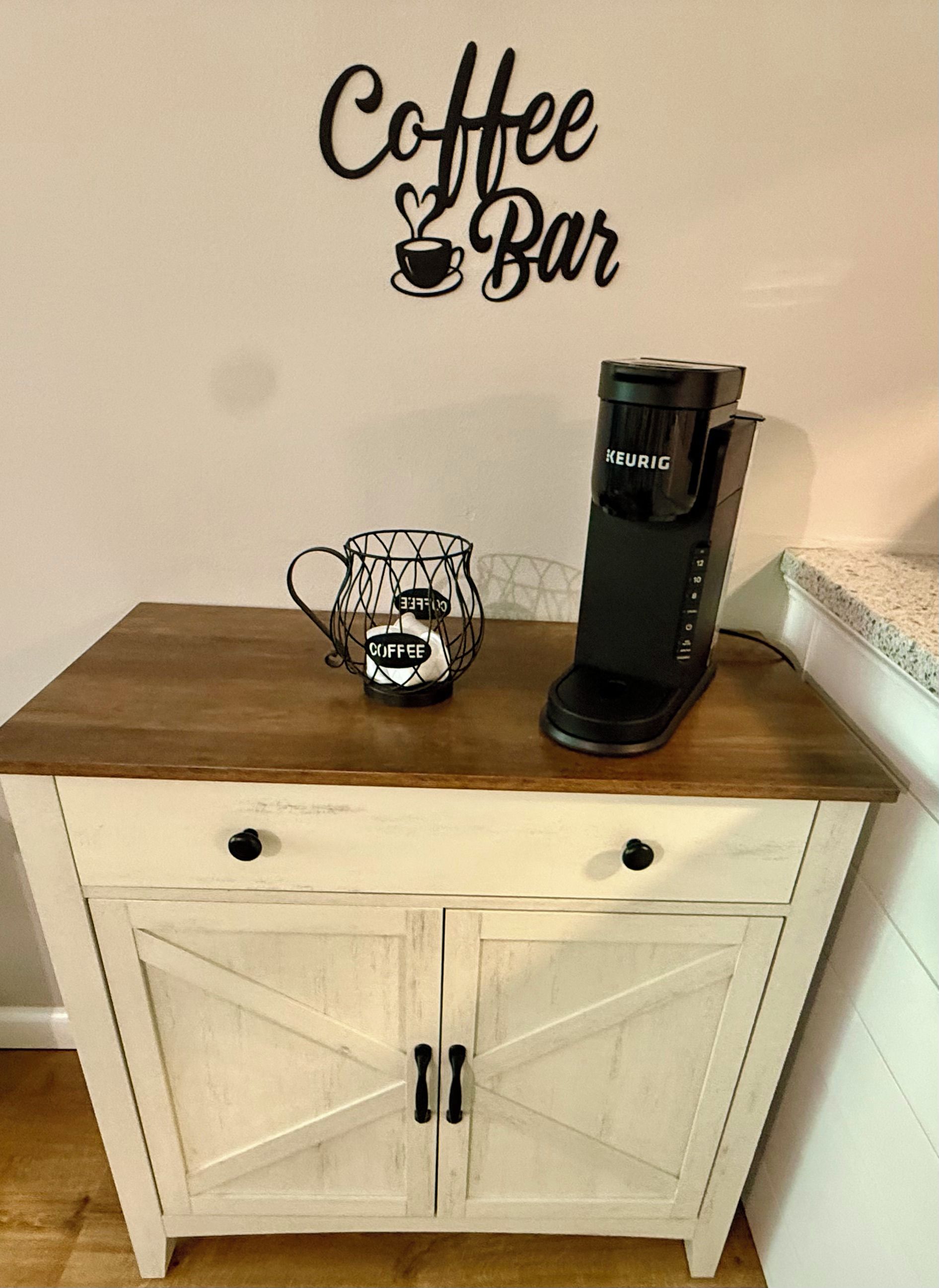 Ett litet kök med en kaffebryggare, en kaffekanna och en skylt på väggen med texten ”Kaffebar”.
