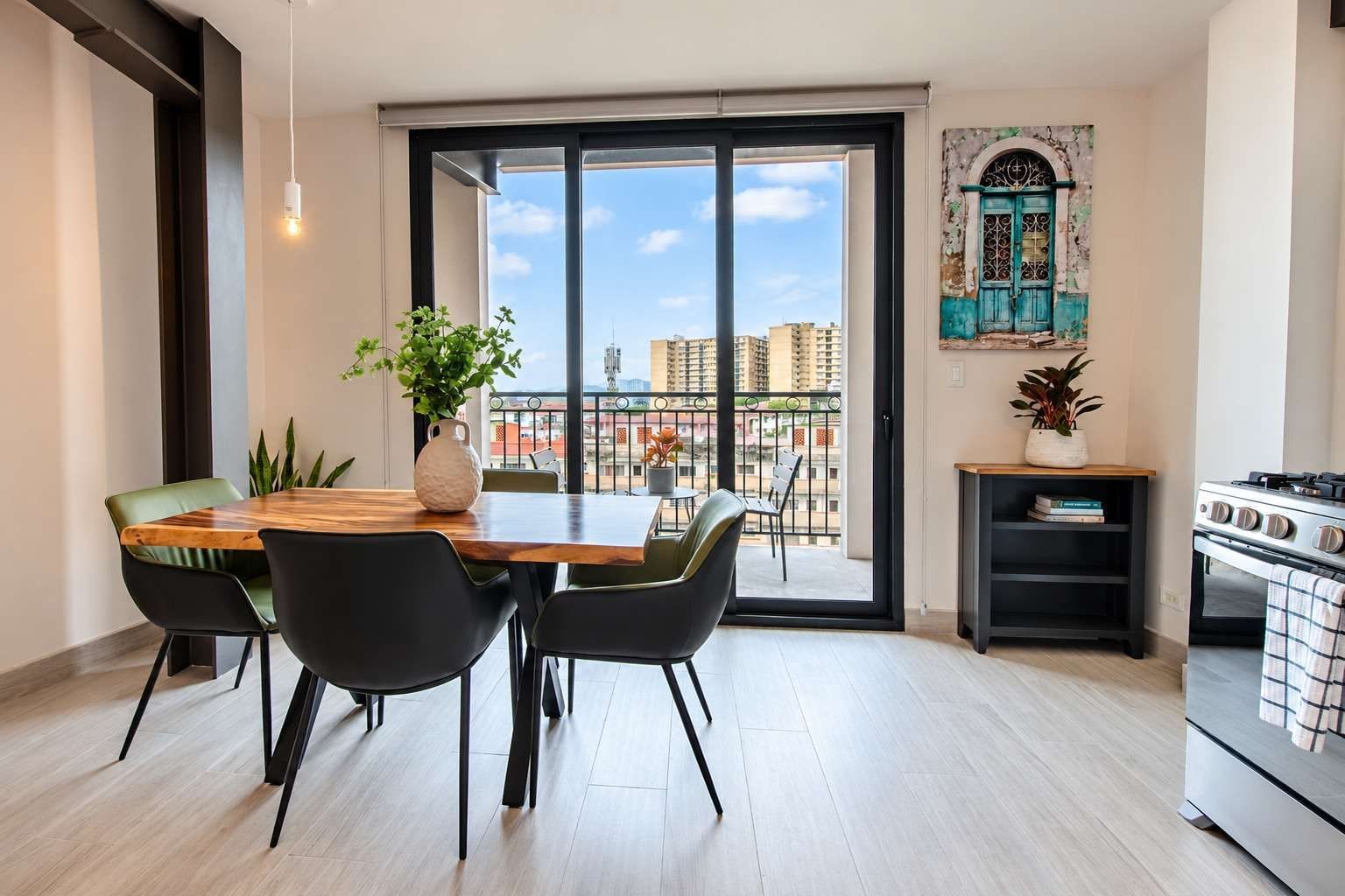 Eine moderne Küche mit Essbereich, einem großen Fenster und Blick auf die Stadtlandschaft.