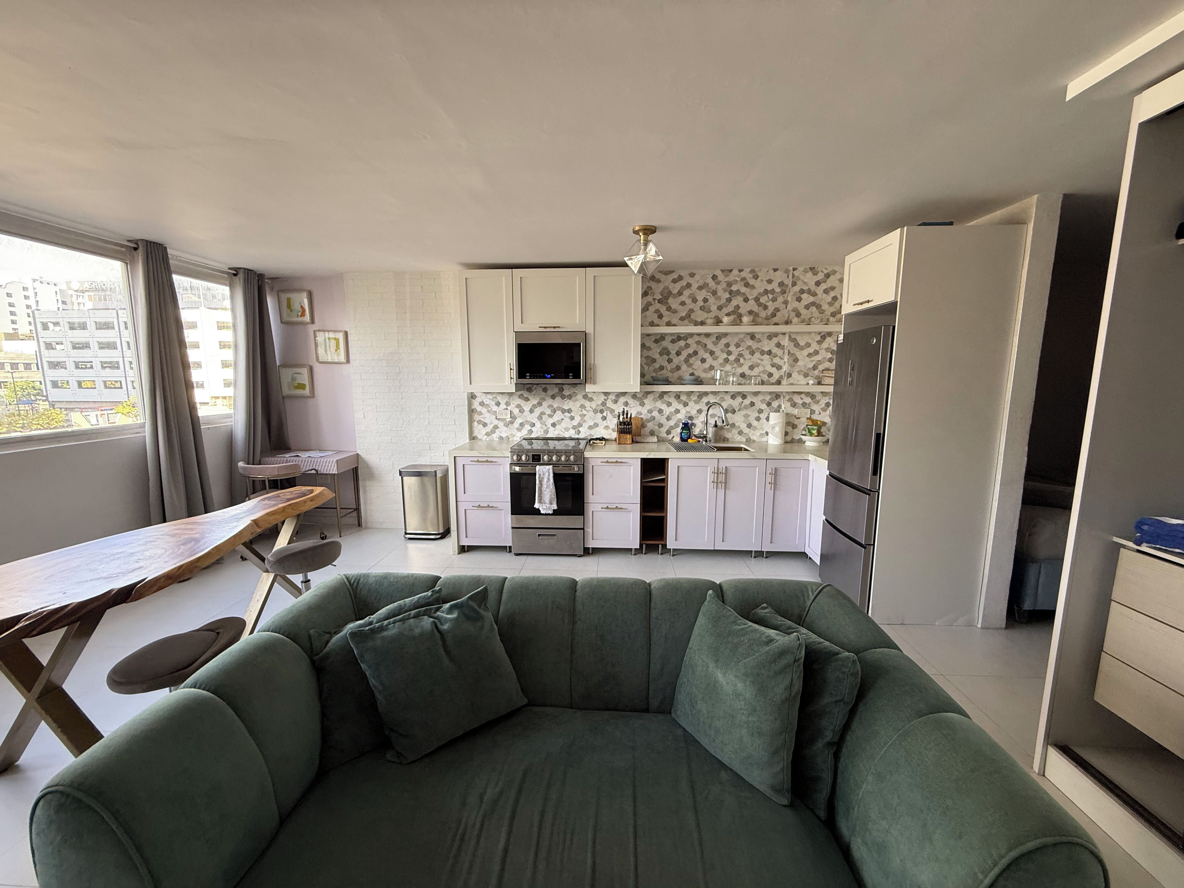 A modern kitchen with white cabinets, a stainless steel stove, and a refrigerator.