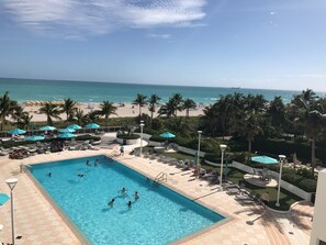 Ein Poolbereich mit Blick auf Strand und Meer.