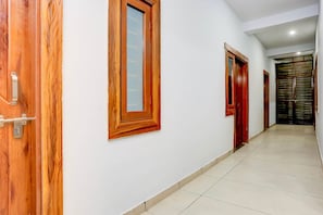A hallway with wooden doors and a tiled floor.