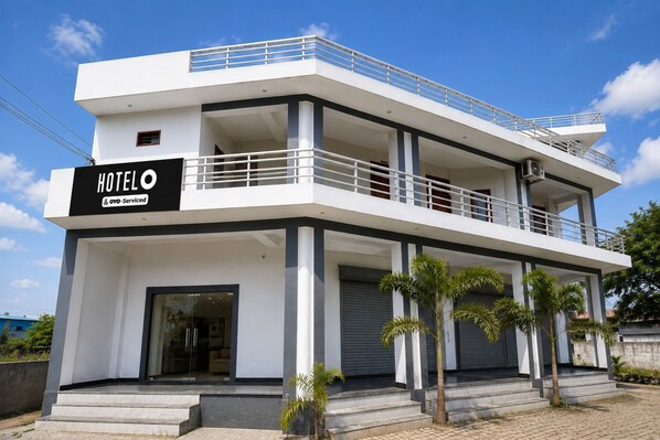 A modern hotel with a two-story structure, a balcony on the upper floor, and a sign indicating it is serviced by Agoda.