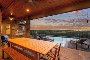 A wooden deck with a pool, outdoor seating, and a view of the landscape. - Solterra Hilltop | Pool | Grill + Endless Views! (Fredericksburg)