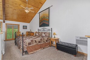 A bedroom with a bed, a ceiling fan, a window, a radiator, and a painting on the wall. - Spacious 2-bedroom loft condo in downtown Estes Park - walk to restaurants/shops (Estes Park)