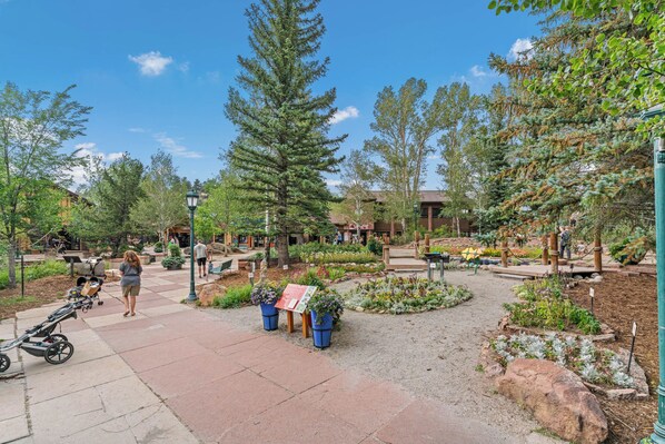 A landscaped garden area with pathways, benches, and potted plants.