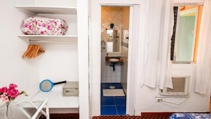 Une salle de bain avec un sol carrelé de carreaux bleus, un lavabo blanc et un espace douche.