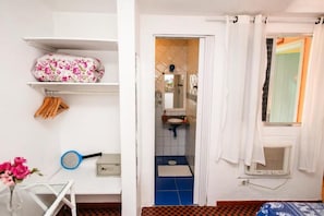 A bathroom with a blue tiled floor, a white sink, and a shower area. - Canto das Laranjeiras Tombo  (Guarujá)