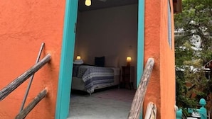 Une pièce avec un lit, un ventilateur de plafond et une fenêtre.