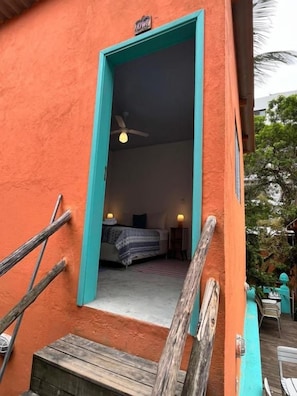A room with a bed, a ceiling fan, and a window. - Canto das Laranjeiras Tombo  (Guarujá)