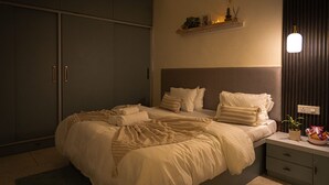 Ein Schlafzimmer mit Bett, Nachttischen, einem Kleiderschrank und einem Regal mit Dekoration.