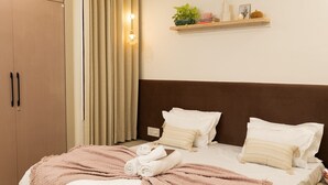 Ein Schlafzimmer mit einem Bett, einem Deckenventilator, einem Nachttisch, einem Regal mit Dekoration und einem Kleiderschrank.