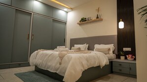 Ein Schlafzimmer mit einem Bett, Nachttischen, einem Kleiderschrank und einem Deckenventilator.