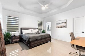 A bedroom with a bed, bedside tables, a desk, and a chair. - Spacious 3-bedroom house with Mini Golf in sunny Tampa (Tampa)