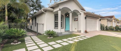 A single-story house with a front porch, a garage, and a well-maintained lawn.