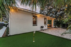 A house with a patio area, a small lawn, and a grill. - Spacious 3-bedroom house with Mini Golf in sunny Tampa (Tampa)