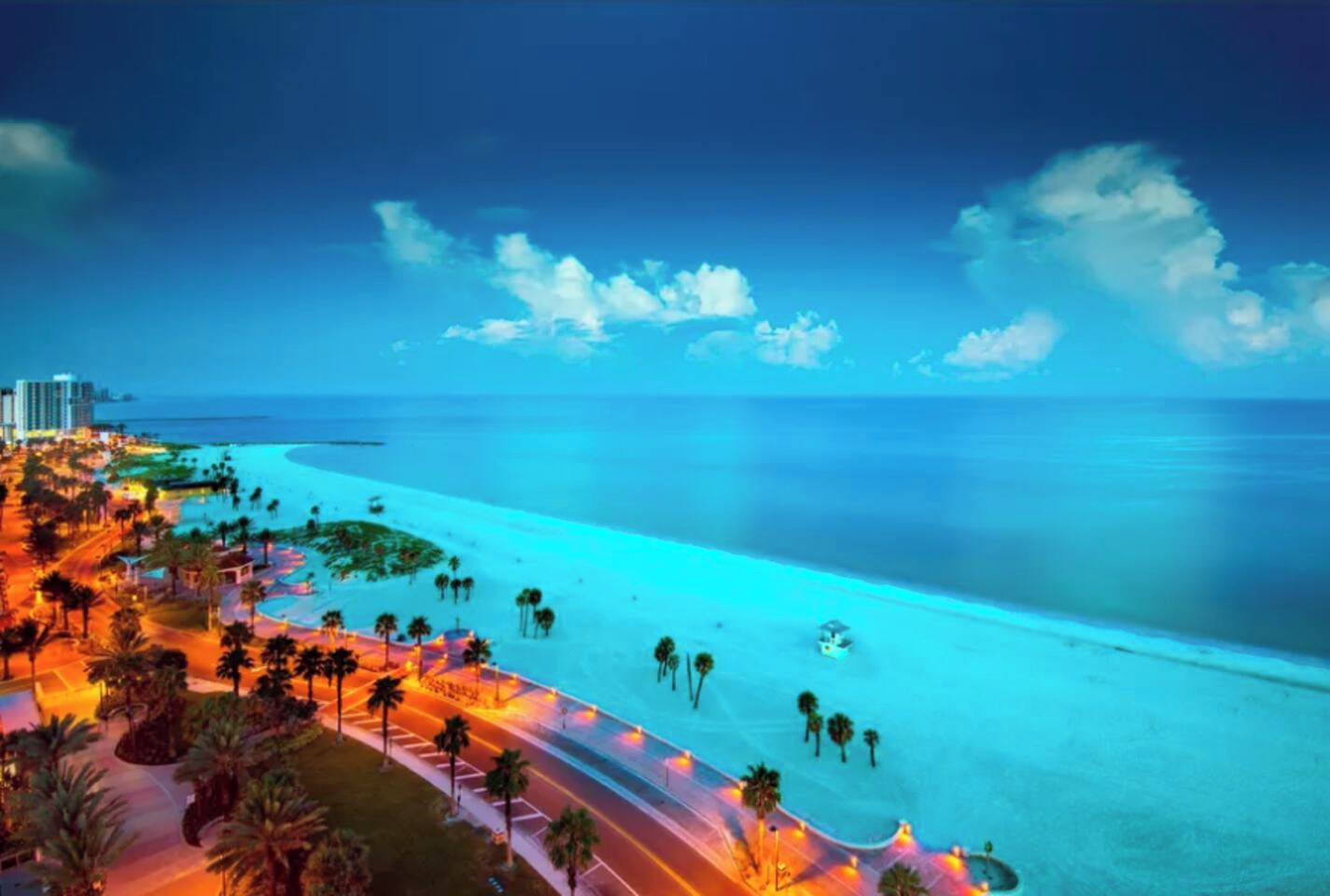 Ein Küstenresort mit Strandzugang, Palmen und einer Straße, die zum Strand führt.