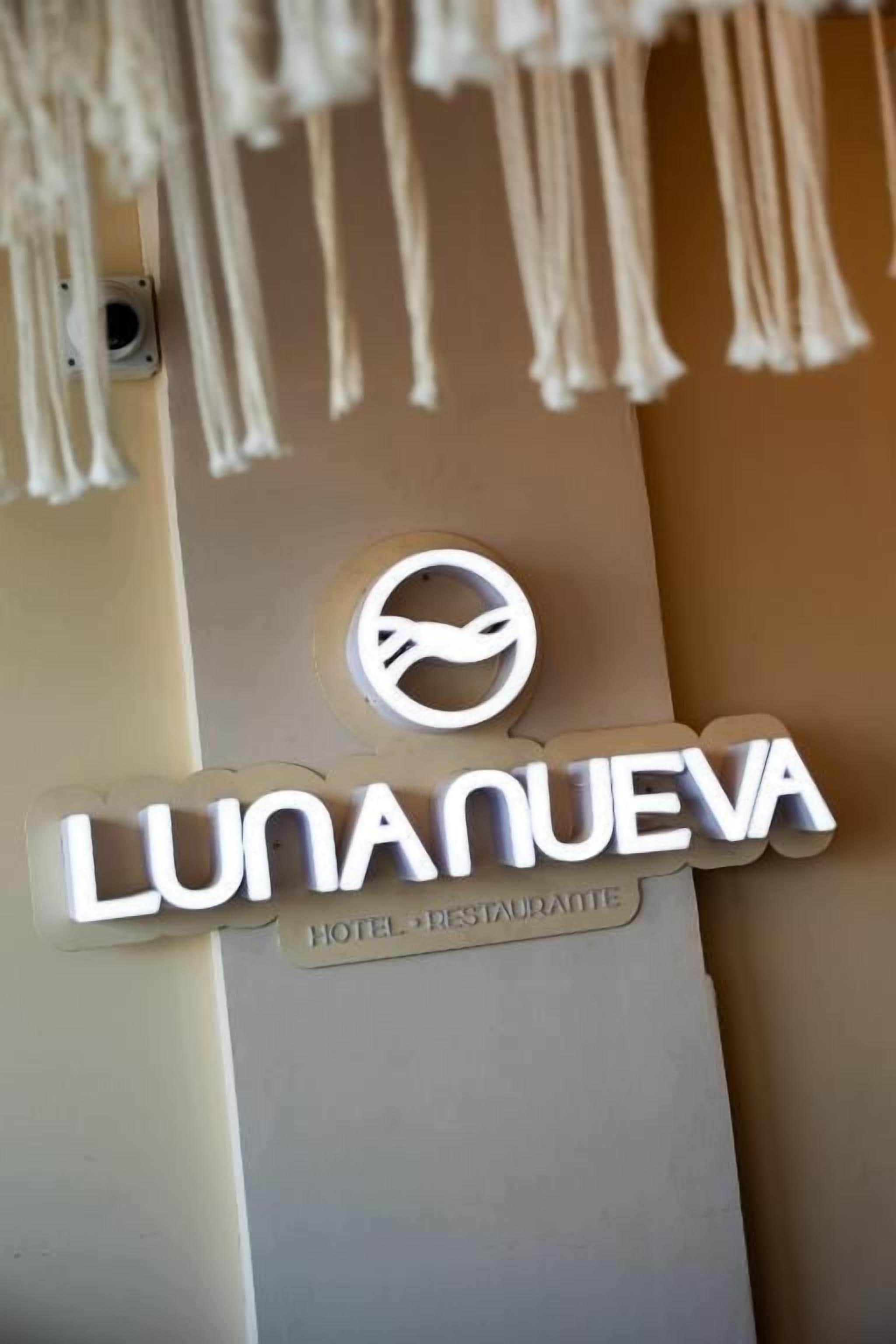 Placa de hotel com o nome 'LUNANUEVA HOTEL RESTAURANTE' e um logotipo.