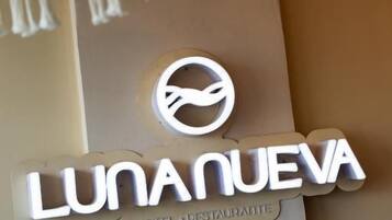 Placa de hotel com o nome 'LUNANUEVA HOTEL RESTAURANTE' e um logotipo.