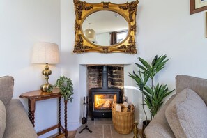 A cozy living room with a fireplace, a mirror, a lamp, and two sofas. - Belmont House - 4 bed, ensuites, private parking (Lincolnshire)