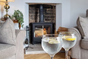 Two glasses of water with lemon slices on a wooden table in a living room with a fireplace. - Belmont House - 4 bed, ensuites, private parking (Lincolnshire)
