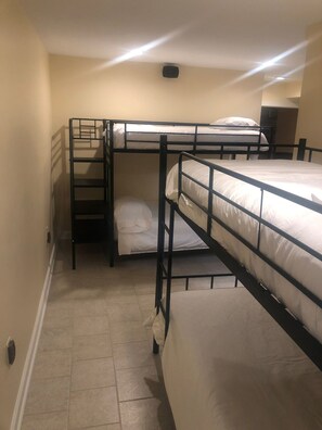 Ein Schlafzimmer mit Etagenbetten, einer kleinen Schreibtisch und einer Wandleuchte.