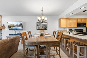 A modern kitchen with wooden cabinets, a built-in microwave, and a granite countertop. - Snowy Owl Lodge | Walk to Slopes & Shared Hot Tub (Breckenridge)