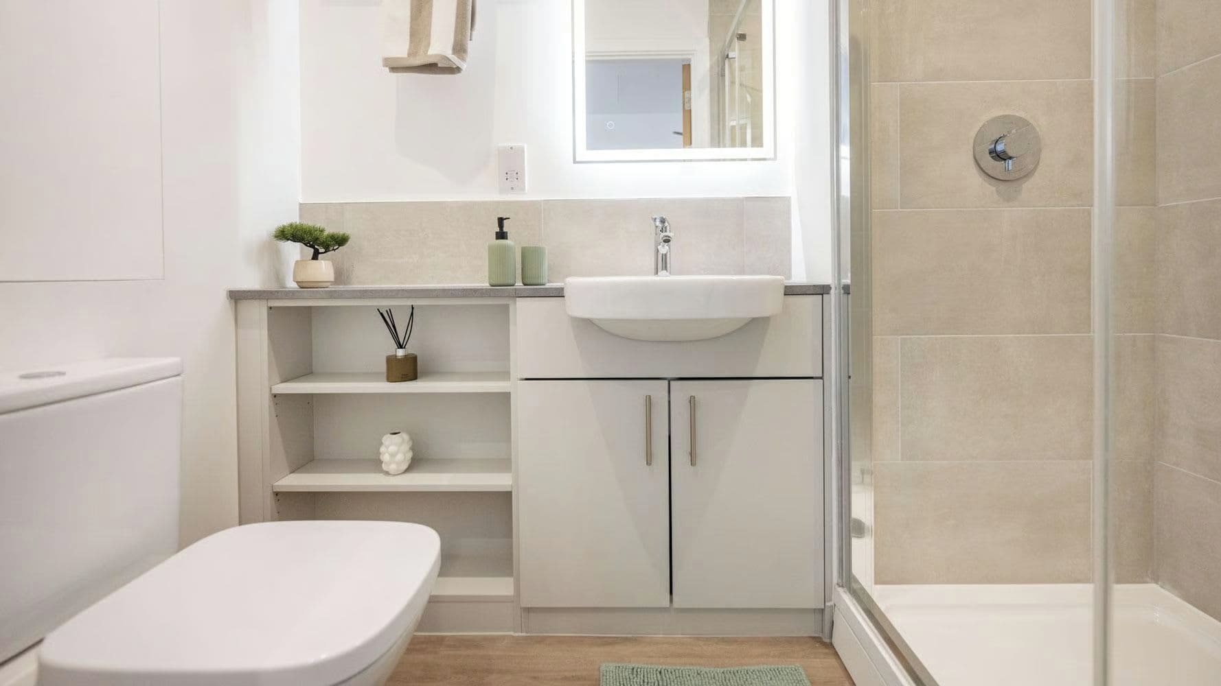 Un baño moderno con inodoro, lavamanos y ducha.