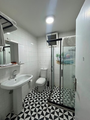 A bathroom with a white sink, toilet, and shower enclosure. - Pendik Çarşı Günlük Daire (Istanbul)