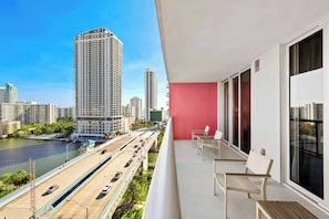 A balcony with a view of a river and cityscape, including high-rise buildings. - Stylish Modern 1BR, Bay View Balcony, Resort Style (Hallandale Beach)