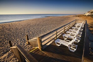 A wooden deck with white lounge chairs facing the beach. - BLOCK Blue Ridge Village 1br (Banner Elk)