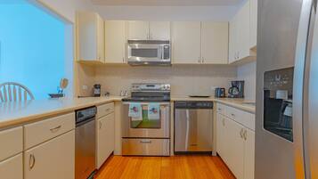 A compact kitchen with a microwave, oven, and dishwasher.
