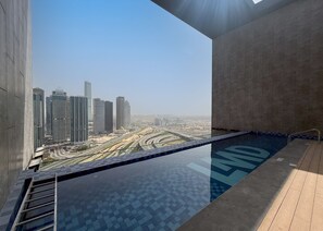 A modern building with a rooftop pool overlooking a cityscape. - Stayshort - Chic 1 Bedroom Unit in Dubai Marina That Sleeps 4 (Dubai)