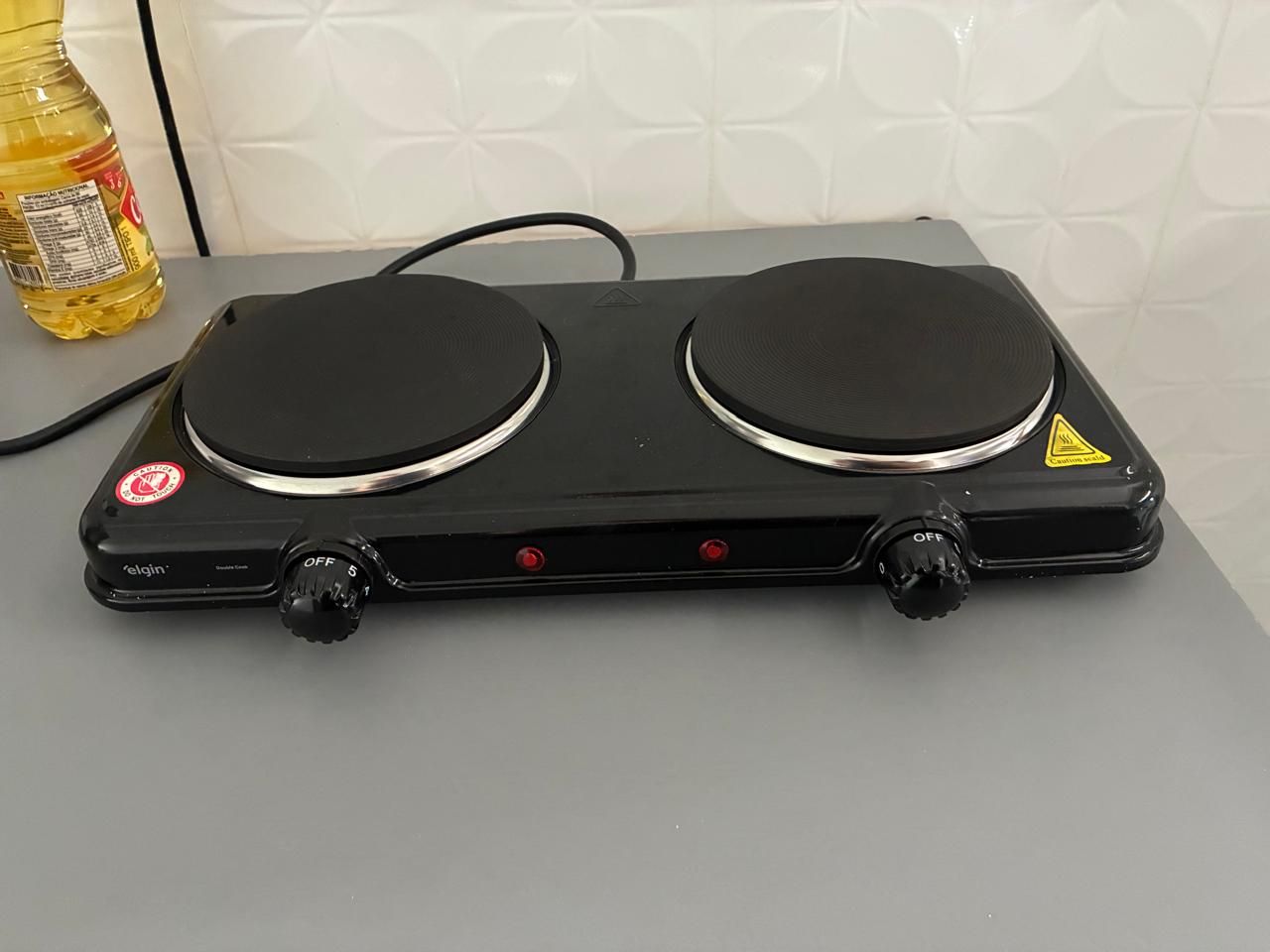 A black electric stove with two burners and a control panel.