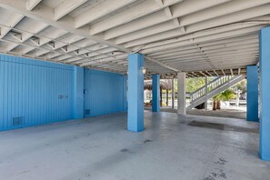 Ein Innenraum mit Betonboden, blauen Wänden und einer Treppe, die zu einem Außenbereich führt.