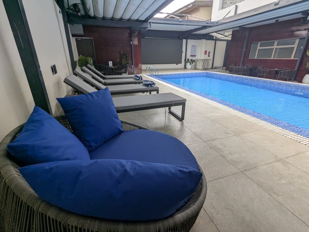 A poolside area with lounge chairs and a pool.
