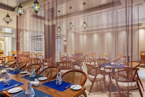 A dining area with tables set for service, chairs, and hanging decorative lights. - Best Western Plus Ambience Hotel Ikeja (Lagos)